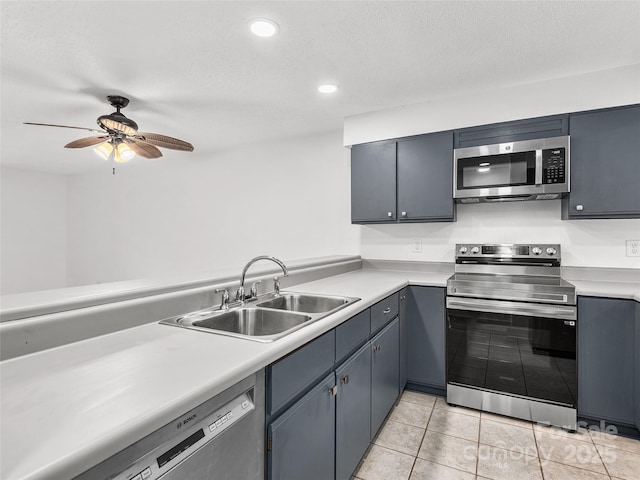 kitchen with appliances with stainless steel finishes, light countertops, and a sink