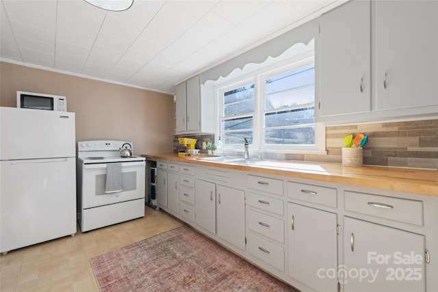 kitchen featuring wood counters, sink, crown molding, white appliances, and decorative backsplash