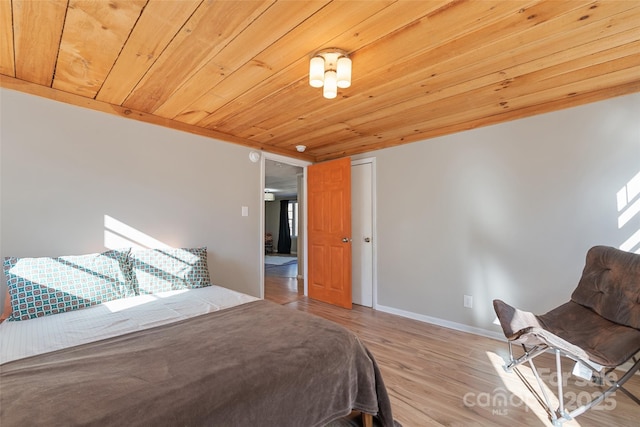 bedroom with light hardwood / wood-style flooring and wooden ceiling