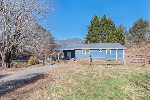 view of front of house with a mountain view and a front lawn