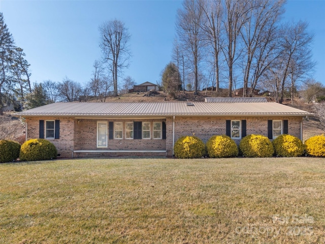 ranch-style house with crawl space, metal roof, brick siding, and a front lawn