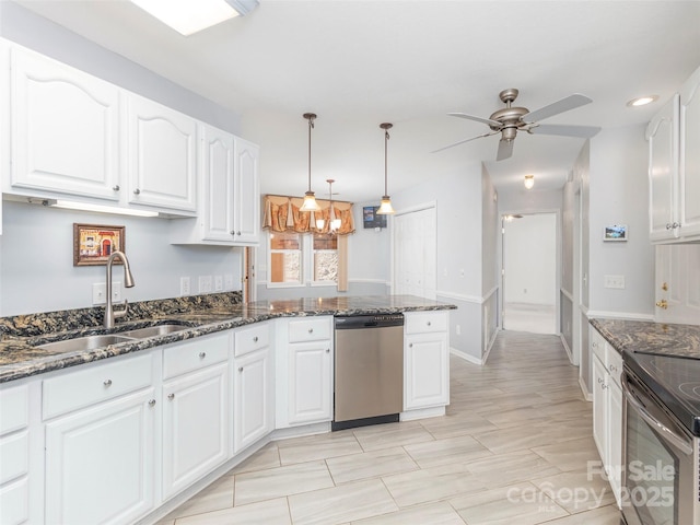 kitchen featuring white cabinetry, dark stone counters, appliances with stainless steel finishes, and a sink