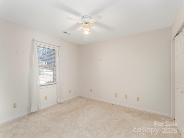 spare room featuring visible vents, baseboards, light colored carpet, and ceiling fan