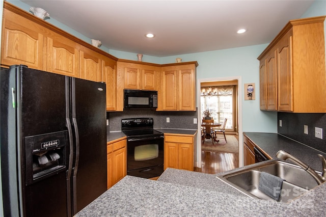 kitchen featuring sink, hardwood / wood-style flooring, and black appliances