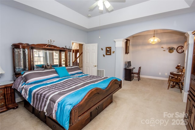 carpeted bedroom with ceiling fan and decorative columns