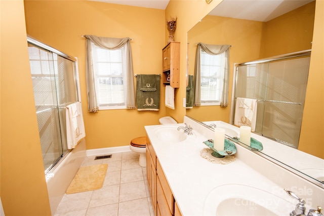 full bathroom featuring tile patterned flooring, vanity, shower / bath combination with glass door, and toilet