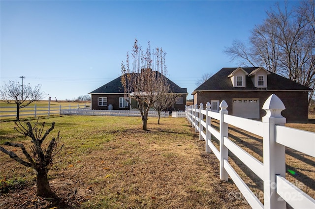 view of yard featuring a garage and a rural view