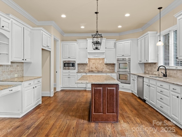 kitchen featuring white cabinetry, decorative light fixtures, appliances with stainless steel finishes, and a kitchen island