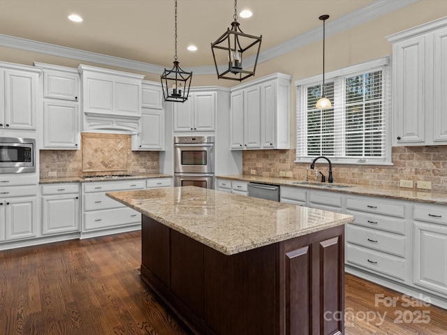 kitchen featuring a kitchen island, white cabinetry, sink, hanging light fixtures, and stainless steel appliances