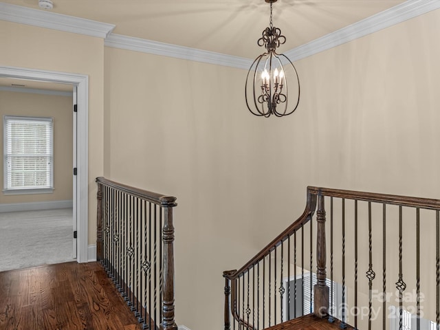 stairway with hardwood / wood-style floors, a notable chandelier, and ornamental molding