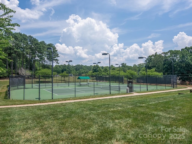 view of tennis court featuring a lawn