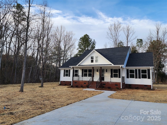 view of front facade with roof with shingles, a porch, and crawl space