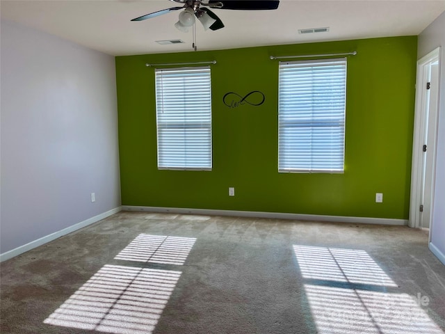 carpeted empty room with ceiling fan and a healthy amount of sunlight