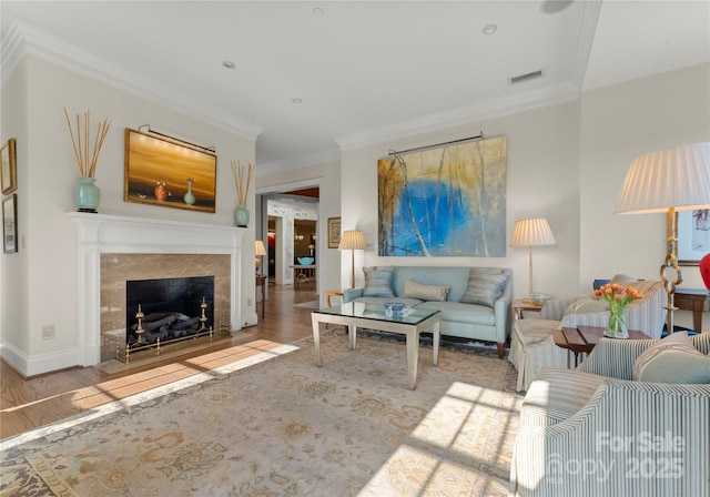 living room with crown molding, a fireplace, and hardwood / wood-style floors