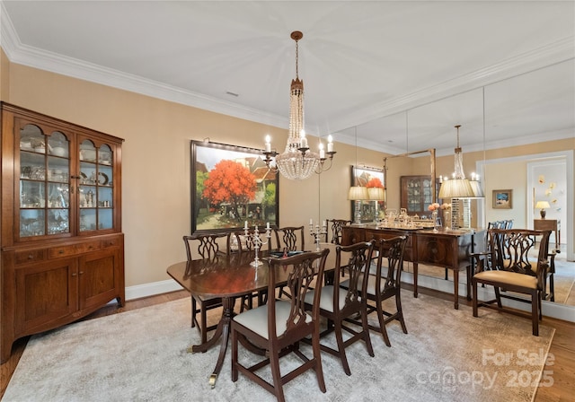 dining space with ornamental molding, a chandelier, and light hardwood / wood-style flooring