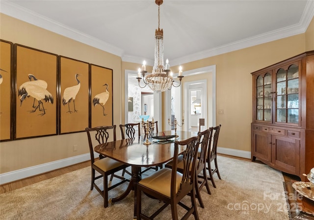 dining space featuring an inviting chandelier, crown molding, and light hardwood / wood-style flooring