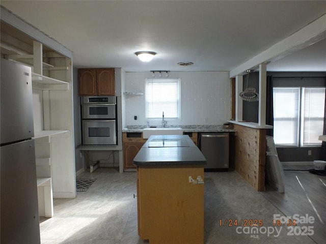 kitchen featuring sink, a kitchen island, a healthy amount of sunlight, and appliances with stainless steel finishes