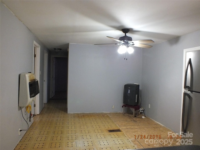 unfurnished room featuring ceiling fan and heating unit