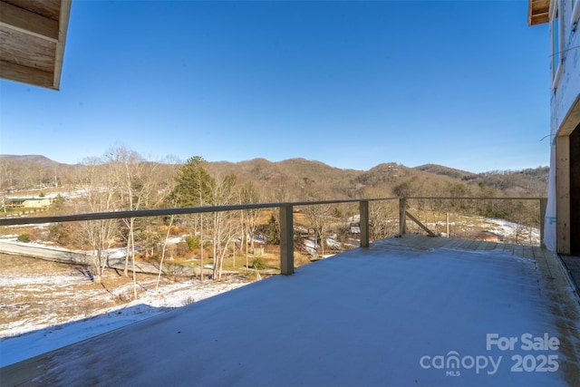 snow covered back of property with a mountain view