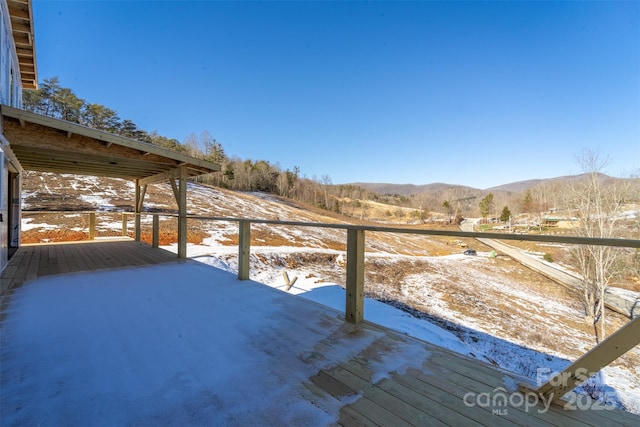 snow covered deck featuring a mountain view