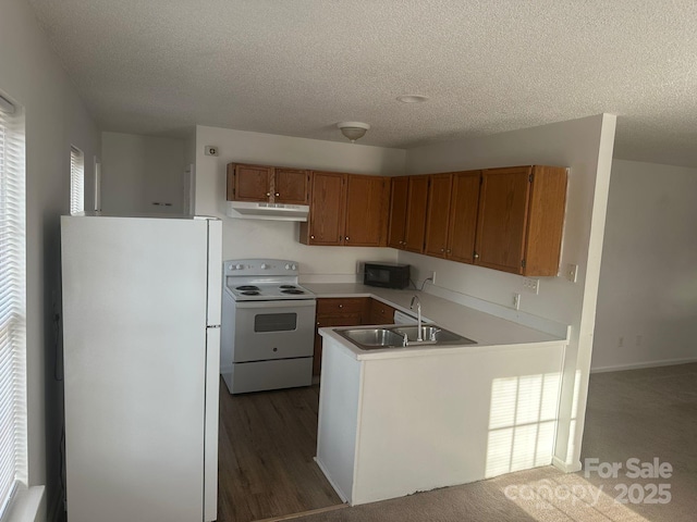 kitchen featuring sink, a textured ceiling, white appliances, and kitchen peninsula