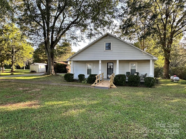 view of front of house featuring a shed, a front lawn, and covered porch