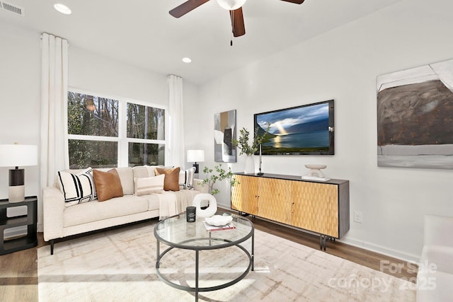 living room featuring wood-type flooring and ceiling fan