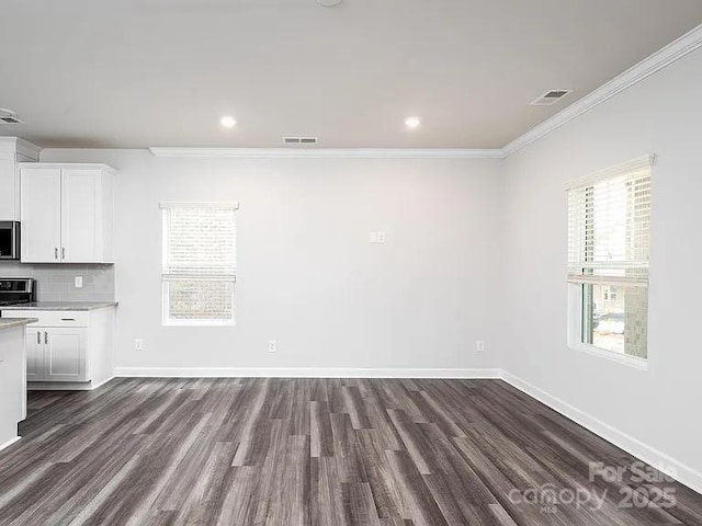 interior space featuring white cabinetry, dark hardwood / wood-style flooring, decorative backsplash, ornamental molding, and stove