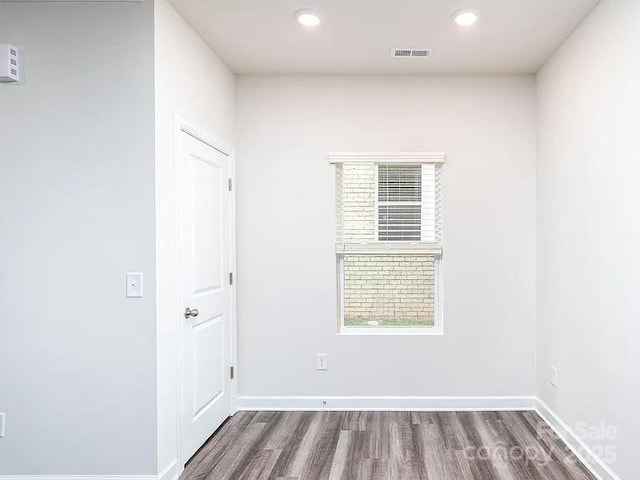 spare room featuring a healthy amount of sunlight and dark hardwood / wood-style floors