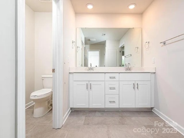 bathroom with vanity, tile patterned flooring, and toilet