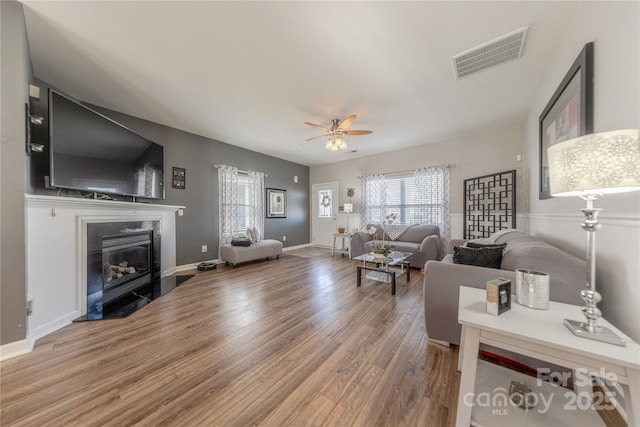 living room featuring wood-type flooring and ceiling fan