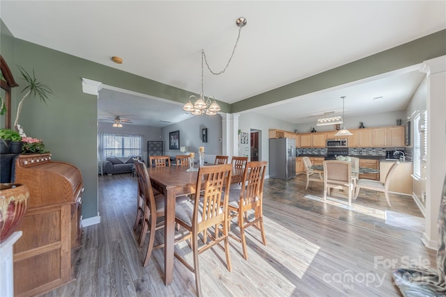 dining area featuring light hardwood / wood-style floors, ceiling fan, and ornate columns