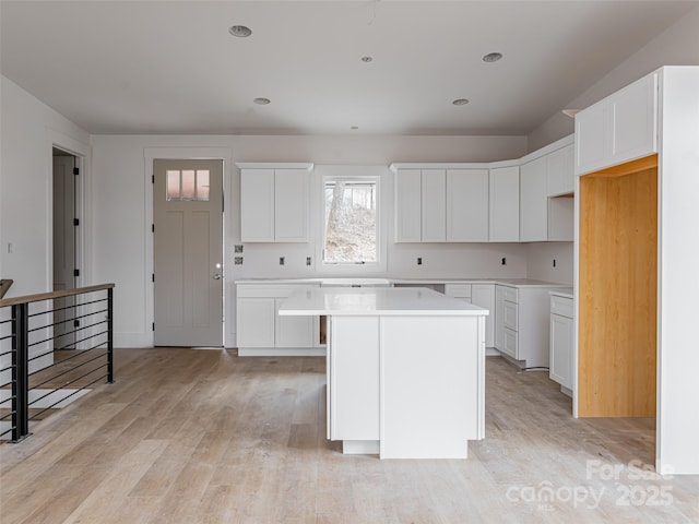 kitchen featuring light hardwood / wood-style flooring, a center island, and white cabinets