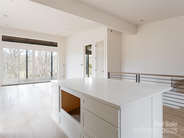 kitchen featuring a kitchen island, white cabinets, and light wood-type flooring