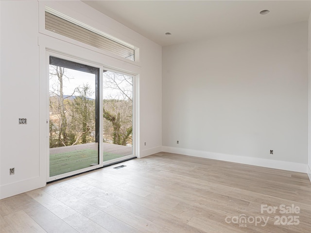 empty room with light hardwood / wood-style flooring