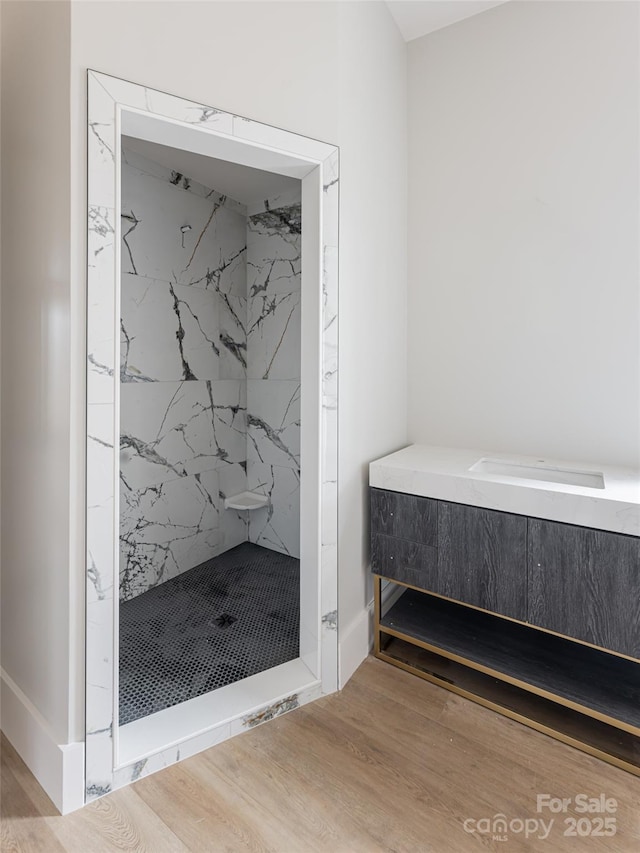 bathroom featuring a tile shower and hardwood / wood-style flooring