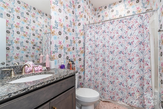 bathroom featuring curtained shower, vanity, and toilet