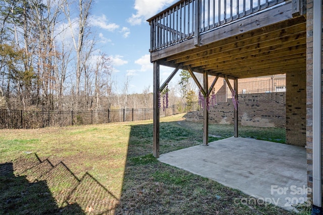 view of yard featuring a patio area, fence, and a wooden deck