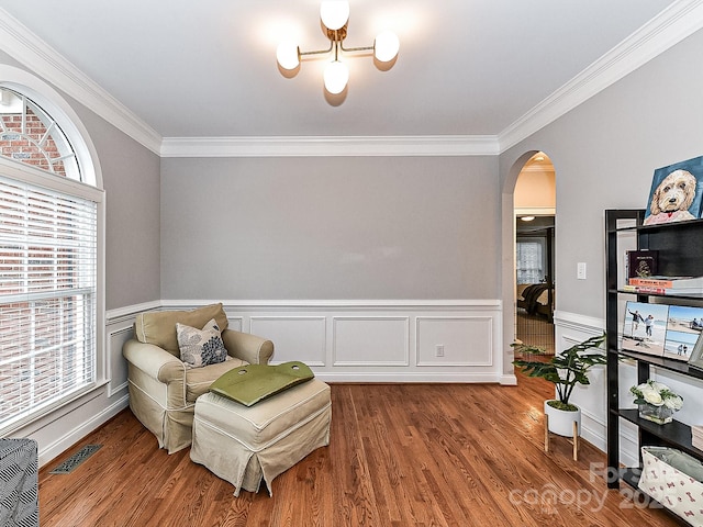 living area featuring hardwood / wood-style flooring and ornamental molding