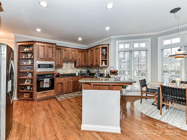 kitchen with hardwood / wood-style flooring, ornamental molding, stainless steel appliances, and decorative backsplash