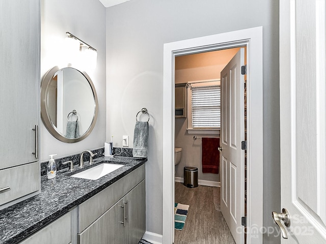 bathroom with hardwood / wood-style flooring, vanity, and toilet