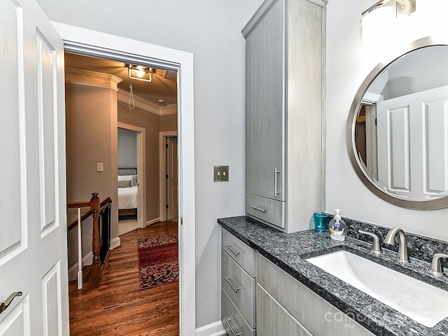 bathroom with wood-type flooring, vanity, and crown molding