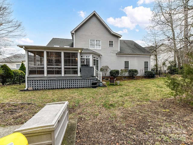 back of house featuring a lawn and a sunroom