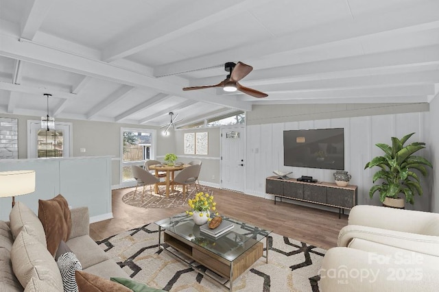 living room featuring lofted ceiling with beams, ceiling fan, and light wood-type flooring