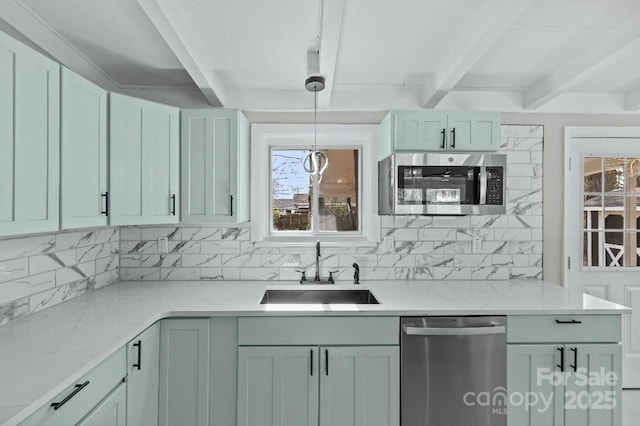 kitchen with sink, appliances with stainless steel finishes, light stone countertops, decorative backsplash, and decorative light fixtures