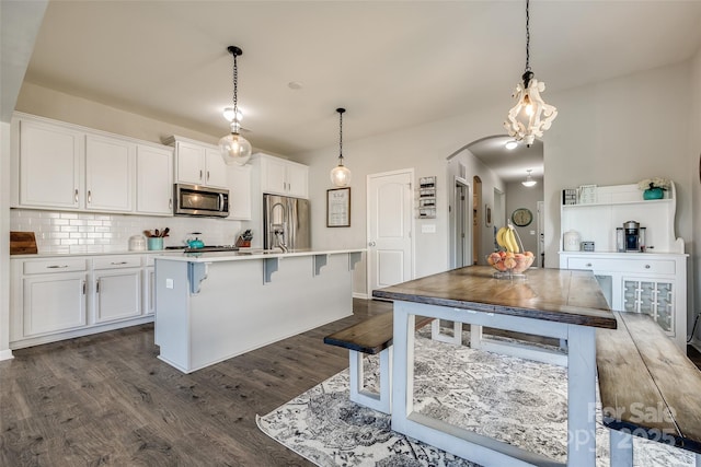 kitchen featuring hanging light fixtures, white cabinets, and appliances with stainless steel finishes