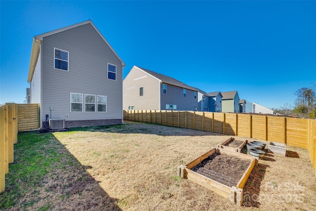 back of house with central AC unit and a lawn