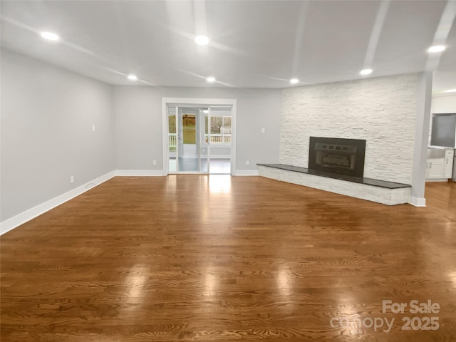 unfurnished living room featuring a fireplace and dark hardwood / wood-style flooring