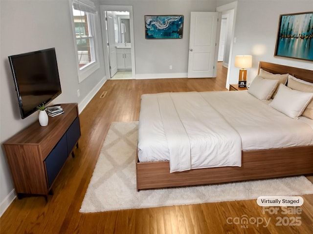 unfurnished bedroom featuring connected bathroom and hardwood / wood-style flooring