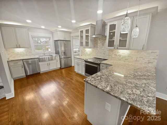 kitchen featuring white cabinetry, decorative light fixtures, wall chimney exhaust hood, and appliances with stainless steel finishes